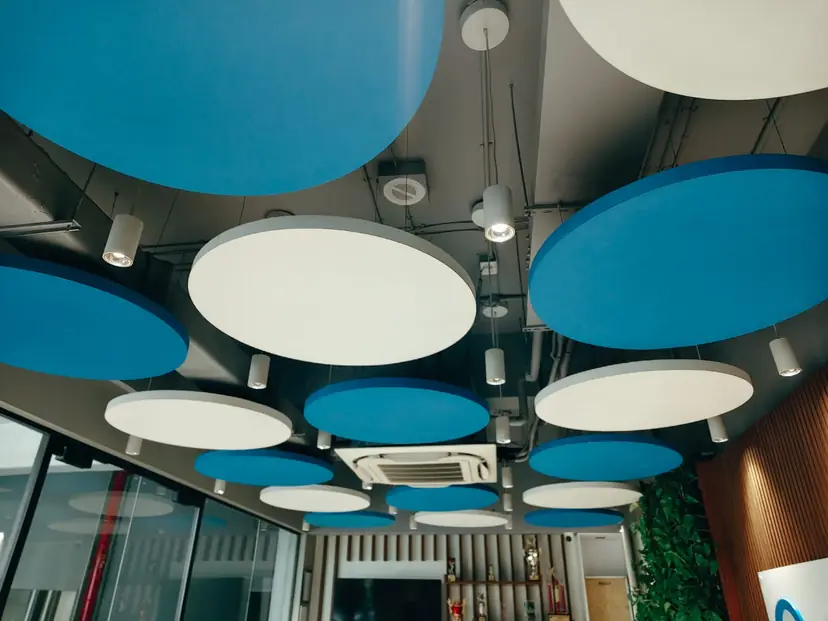 Two-tone decorative acoustic ceiling discs finished in a blue and white paint scheme